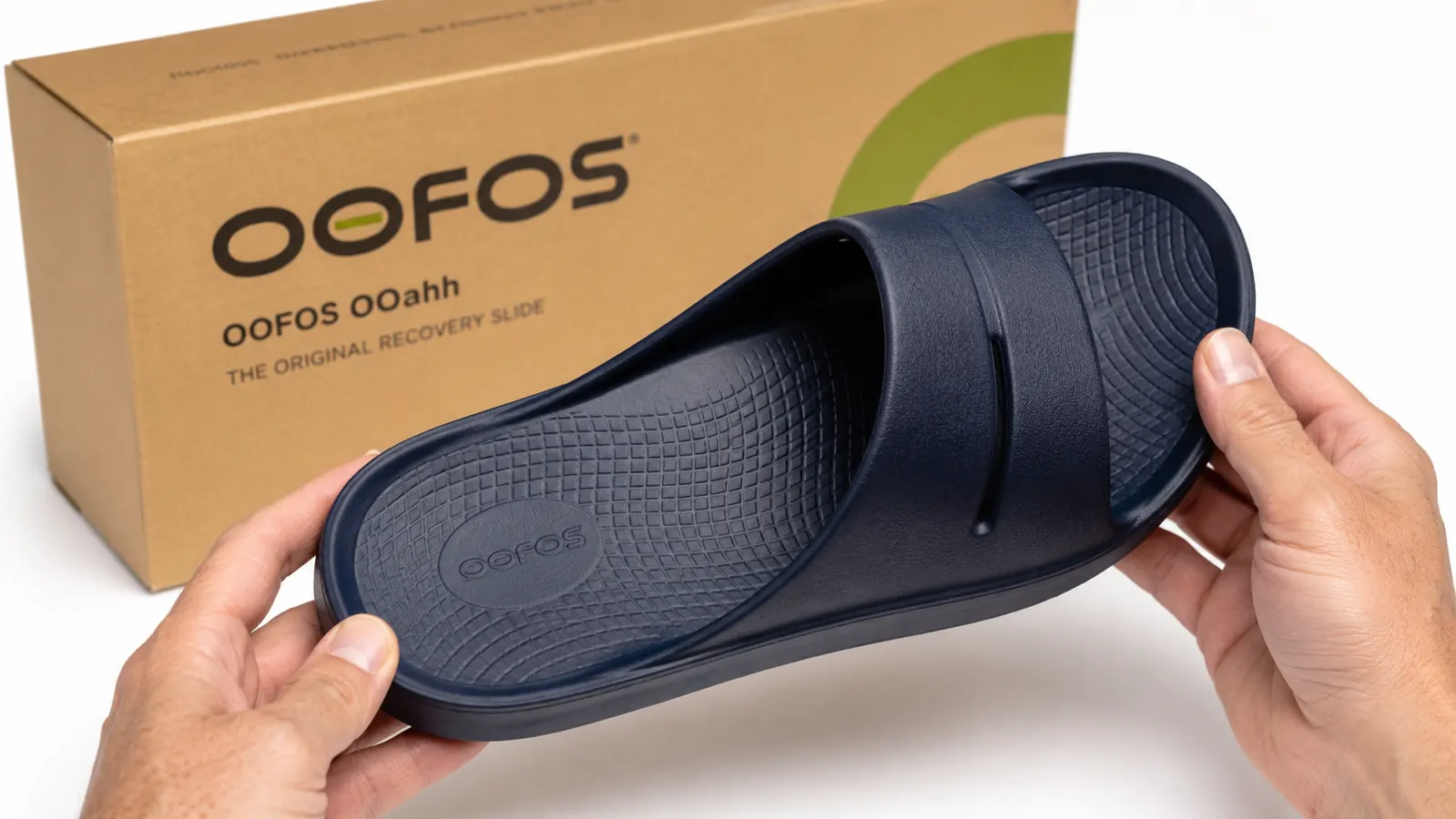Close-up of OOFOS OOahh recovery slide showing the contoured foam footbed and arch support